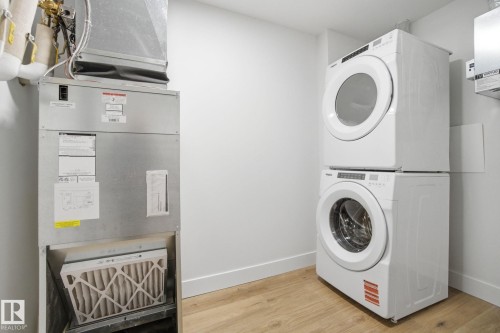 This property includes a stackable washer and dryer, along with a furnace, providing essential utilities - 516 260 Bellerose Dr, St. Albert, AB - Indoor Photo Showing Laundry Room