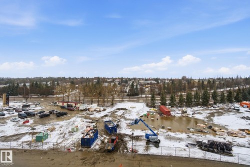 Aerial view of the surrounding neighborhood, featuring a clear sky with scattered clouds and distant trees - 516 260 Bellerose Dr, St. Albert, AB - Outdoor With View