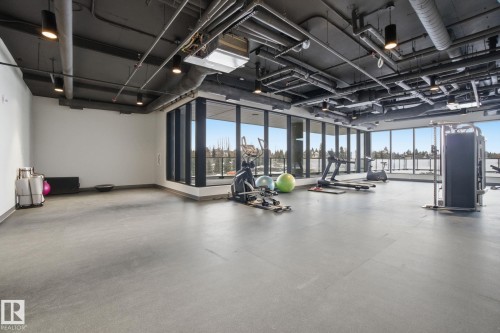 Spacious fitness area featuring floor-to-ceiling windows, exposed ductwork, and a durable rubber floor - 516 260 Bellerose Dr, St. Albert, AB - Indoor Photo Showing Gym Room