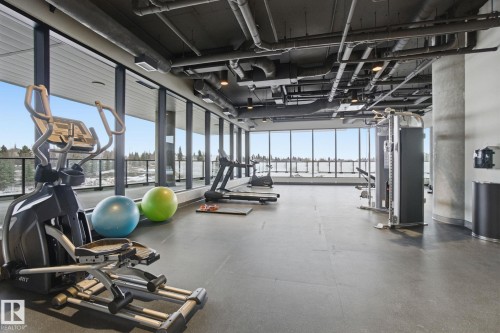 The property features an exercise room with floor-to-ceiling windows, providing expansive views - 516 260 Bellerose Dr, St. Albert, AB - Indoor Photo Showing Gym Room