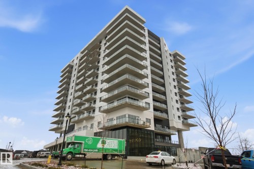 This building features a contemporary design with numerous balconies, each offering clear glass railings - 516 260 Bellerose Dr, St. Albert, AB - Outdoor With Balcony With Facade