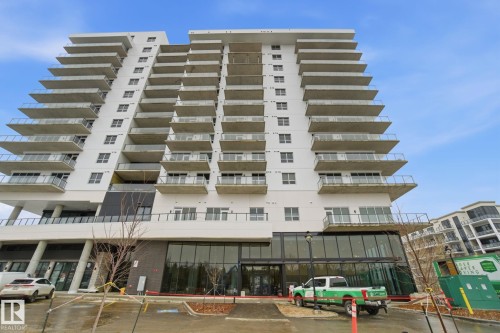 The property features a modern high-rise building with a white facade and numerous balconies with glass railings - 516 260 Bellerose Dr, St. Albert, AB - Outdoor With Balcony With Facade