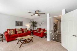 The property features a living room with carpeted flooring, light grey walls, and a ceiling fan - 