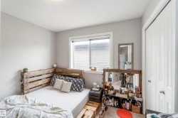 The room features a window with horizontal blinds, light gray walls, and white trim - 