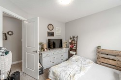 This room features light gray walls, a carpeted floor, and a white interior door - 