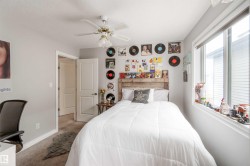 This room features a window providing natural light, a ceiling fan, and light gray walls - 