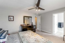 The room features carpeting, light gray walls, and a ceiling fan with integrated lighting - 