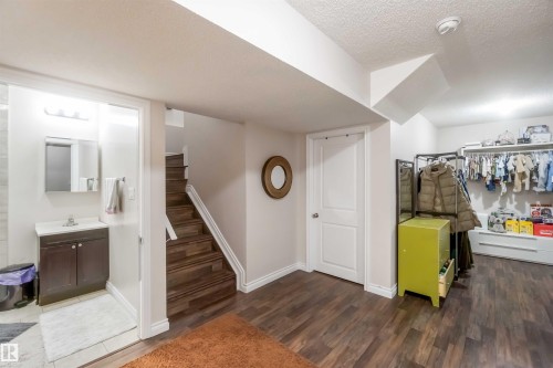 The property features wood flooring, a staircase with wood treads, and white walls - 12232 167B Avenue, Edmonton, AB - Indoor Photo Showing Other Room