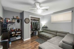This room features wood-look flooring, a closet with a hanging rod, and a ceiling fan with integrated lighting - 