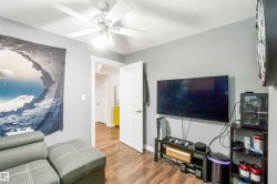 This room features hardwood flooring, light gray walls, and a white ceiling fan - 