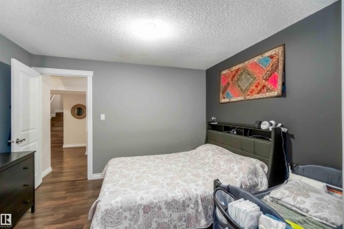 This room features hardwood flooring and a neutral color palette with contrasting accent walls - 12232 167B Avenue, Edmonton, AB - Indoor Photo Showing Bedroom