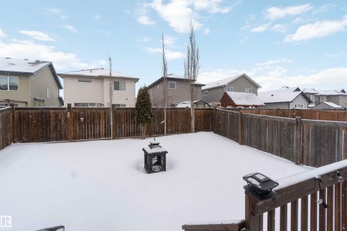 The property features a fenced yard, covered in snow, with a decorative lantern - 12232 167B Avenue, Edmonton, AB - Outdoor
