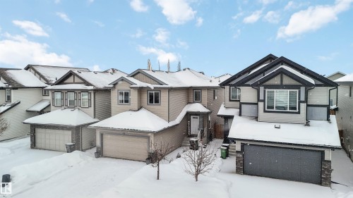 The property features a two-story exterior with light-colored siding, dark trim, and a prominent front-facing garage - 12232 167B Avenue, Edmonton, AB - Outdoor With Facade