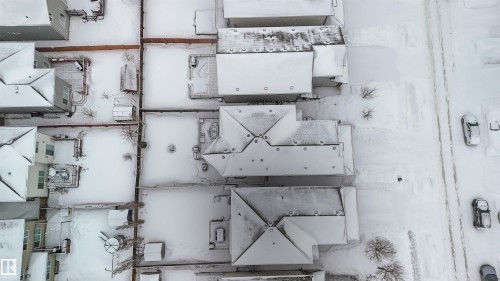 Aerial view showcasing properties with snow-covered roofs and yards, featuring a visible road with parked vehicles - 12232 167B Avenue, Edmonton, AB - 