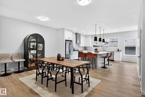 Open concept living space featuring light wood flooring, white walls, and bright overhead lighting - 6127 Carr Road, Edmonton, AB - Indoor