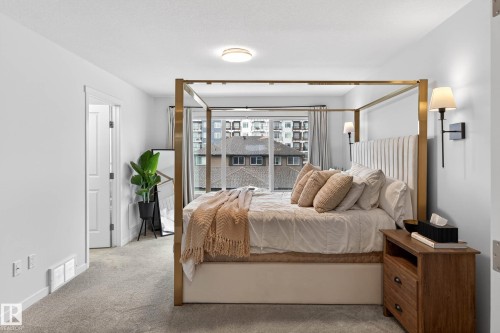 This inviting room features soft gray carpeting, white walls, and a large window providing natural light and exterior views - 6127 Carr Road, Edmonton, AB - Indoor Photo Showing Bedroom