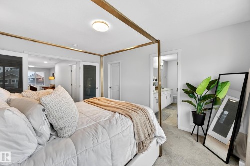 The bedroom features light gray walls and carpeting, with an overhead flush-mount light fixture - 6127 Carr Road, Edmonton, AB - Indoor Photo Showing Bedroom