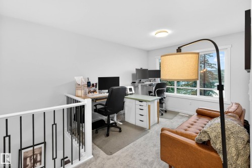 Bright and versatile space featuring light-colored carpeting, a large window offering outdoor views, and a modern ceiling light fixture - 6127 Carr Road, Edmonton, AB - Indoor Photo Showing Office