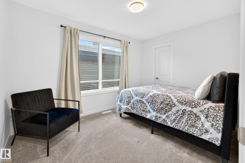 This room features light grey carpeting, a window with blinds and curtains, and a ceiling light fixture - 6127 Carr Road, Edmonton, AB - Indoor Photo Showing Bedroom