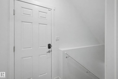 Entryway featuring a white paneled door with a keyless entry lock - 6127 Carr Road, Edmonton, AB - Indoor Photo Showing Other Room
