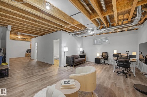 The property features extensive finished flooring, white walls, and exposed wooden ceiling beams - 6127 Carr Road, Edmonton, AB - Indoor Photo Showing Basement