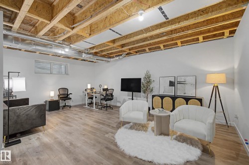 Spacious room with light-colored flooring, exposed ceiling beams, and a window providing natural light - 6127 Carr Road, Edmonton, AB - Indoor Photo Showing Basement
