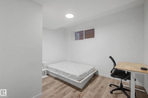 This room features light-colored walls, wood-style flooring, and a window with blinds - 6127 Carr Road, Edmonton, AB - Indoor