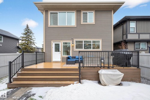 The property features an outdoor deck with black railings and steps leading down to a yard area - 6127 Carr Road, Edmonton, AB - Outdoor With Deck Patio Veranda With Exterior