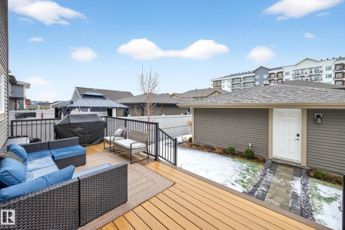 The property features an outdoor deck with wooden flooring and black metal railings - 6127 Carr Road, Edmonton, AB - Outdoor With Deck Patio Veranda With Exterior