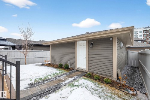This property features a structure with horizontal siding, a white door, and an exterior light fixture - 6127 Carr Road, Edmonton, AB - Outdoor With Exterior