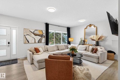 Spacious living area featuring light wood flooring, a large window with dark curtains, and recessed lighting - 6127 Carr Road, Edmonton, AB - Indoor Photo Showing Living Room