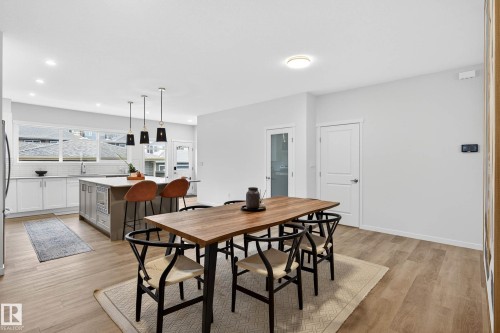 The property features an open-concept living area with light wood-style flooring throughout - 6127 Carr Road, Edmonton, AB - Indoor