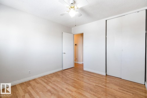This room features light hardwood flooring, white walls, and a white ceiling with a ceiling fan - 7324 77 Street, Edmonton, AB - Indoor Photo Showing Other Room