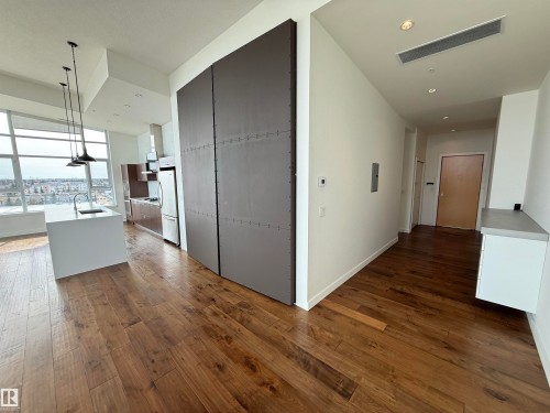 This open-concept living area features rich hardwood flooring and high ceilings with recessed lighting - 710 2504 109 Street, Edmonton, AB - Indoor Photo Showing Other Room