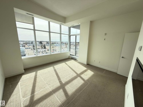 This room features expansive windows offering urban views and abundant natural light - 710 2504 109 Street, Edmonton, AB - Indoor Photo Showing Other Room