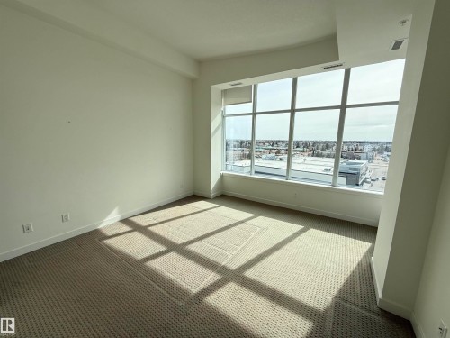 This room features expansive floor-to-ceiling windows, offering broad views of the surrounding urban landscape - 710 2504 109 Street, Edmonton, AB - Indoor Photo Showing Other Room