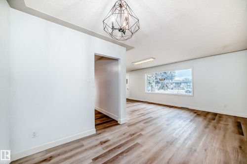 This interior space features light-toned wood-look flooring and white walls throughout - 9126 152 St, Edmonton, AB - Indoor Photo Showing Other Room