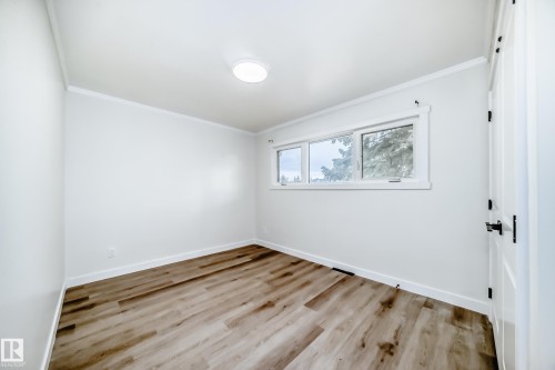 This room features light-colored walls, wood-look flooring, and a multi-pane window with white trim - 9126 152 St, Edmonton, AB - Indoor Photo Showing Other Room