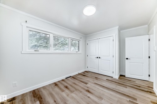 Room featuring light-toned wood-style flooring, white walls, and a window with a view of trees - 9126 152 St, Edmonton, AB - Indoor Photo Showing Other Room