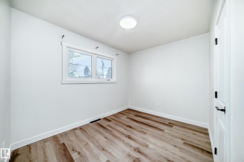 Room featuring light wood-look flooring, white walls, and a window providing natural light - 9126 152 St, Edmonton, AB - Indoor Photo Showing Other Room