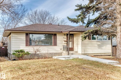 The property features horizontal siding, a brown shingled roof, a front door with a storm door, and a concrete pathway leading to the entrance - 9126 152 St, Edmonton, AB - Outdoor