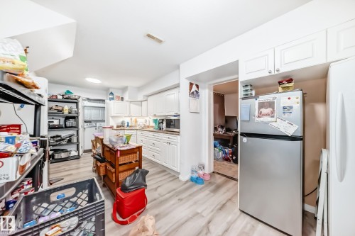 The kitchen features white cabinetry, wood-look countertops, and light-toned flooring - 9126 152 St, Edmonton, AB - Indoor