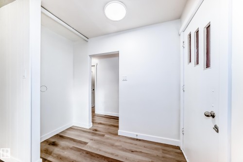 Entryway featuring hardwood-style flooring, a white door with vertical window panels, and a flush mount ceiling light fixture - 9126 152 St, Edmonton, AB - Indoor Photo Showing Other Room