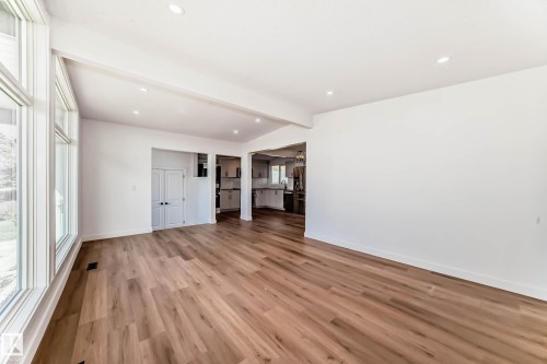Spacious room featuring light-toned wood flooring, recessed lighting, and large windows providing ample natural light - 7220 152A Ave, Edmonton, AB - Indoor Photo Showing Other Room