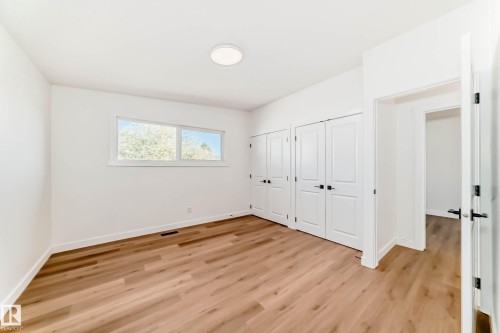 Spacious room featuring light wood flooring, white walls, and a window providing natural light - 7220 152A Ave, Edmonton, AB - Indoor Photo Showing Other Room