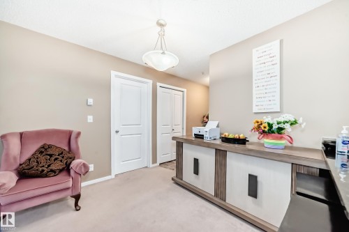 This inviting space features a light-colored carpet, neutral wall paint, and white paneled doors - 116 5810 Mullen Place, Edmonton, AB - Indoor
