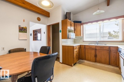 Kitchen featuring wood-finish cabinetry, a double basin sink, and a white countertop - 13437 118 Street, Edmonton, AB - Indoor
