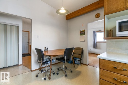 Kitchen area featuring wood-finish cabinetry, solid surface countertops, and an integrated microwave shelf - 13437 118 Street, Edmonton, AB - Indoor Photo Showing Office
