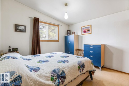Bedroom featuring a window with wood-finish trim, white walls, and a light-colored floor - 13437 118 Street, Edmonton, AB - Indoor Photo Showing Bedroom