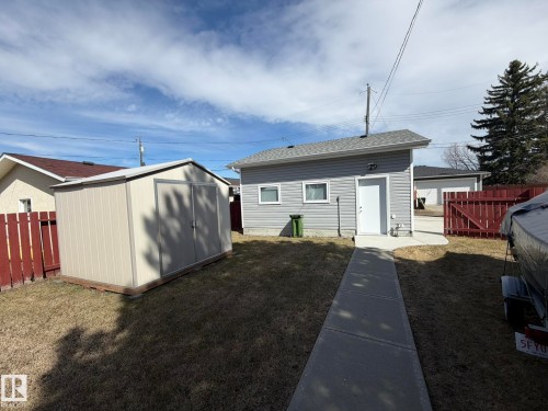 Detached garage with horizontal siding, a white service door, and two small windows - 13437 118 Street, Edmonton, AB - Outdoor